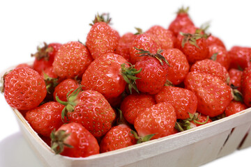 Close Up Of Ripe Red Wild Strawberries (Or A Small Garden Variety) In A Wooden Punnet Basket, Isolated On White Background. Summer Berry Harvest.