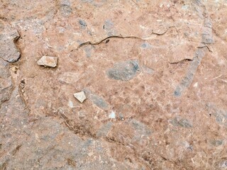 Natural rock texture with cracks and small stone fragments