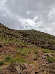 Rugged green landscape with hills under a cloudy sky