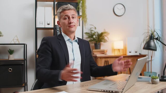 I don't know what to say. Confused young businessman in suit working on laptop at home office. Freelancer feeling embarrassed about ambiguous question, being clueless, having doubts, no answer idea.