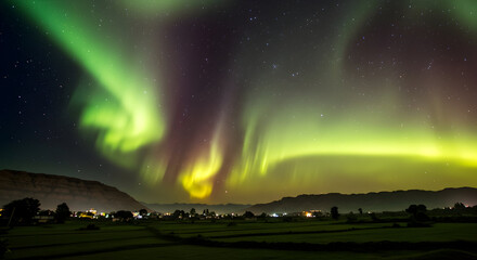 A vibrant saffron white and green aurora borealis over an Indian landscape