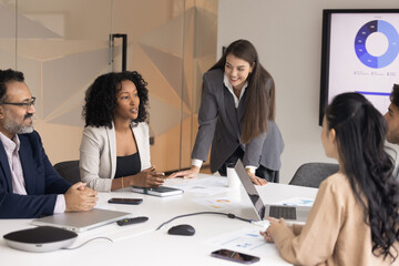 Collaboration in problem solving. Confident young woman business professional manager executive express idea offer corporate strategy to leader and team at brainstorming meeting in office boardroom