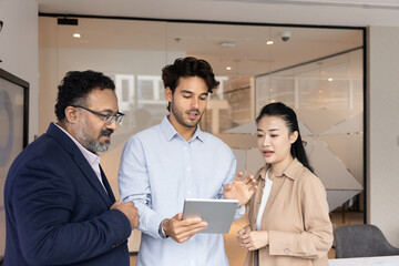 Digital data in business dialogue. Diverse multiracial businesspeople group stand in office use...