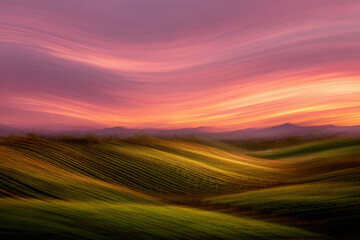 Obraz premium Rolling green hills under a bright sky with soft white clouds drifting across the horizon.