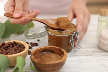 Woman making natural body scrub at white wooden table, closeup