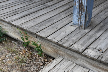 Old wooden decking, multi level with support beam.