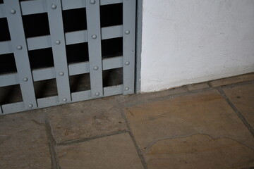 Prison cell door, lower right corner. Stone flooring.