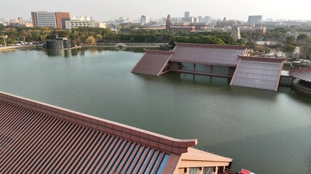 4K aerial footage of traditional-style buildings beside a reflective body of water, captured in daylight with smooth cinematic motion.