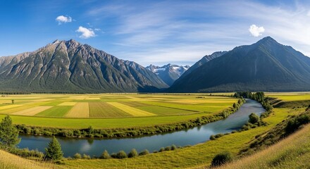 Fototapeta premium Serene River Meanders Through Lush Green Fields with Majestic Mountains