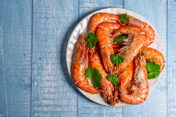 Cooked prawns decorated with parsley leaves on white plate