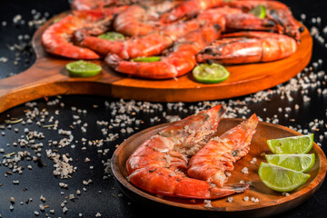 Grilled prawns with lime and coarse salt on wooden plates