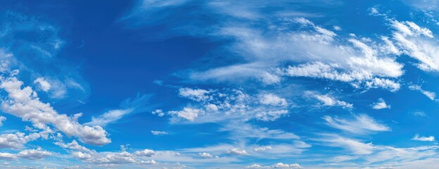 Panoramic view of a vibrant blue sky dotted with fluffy white clouds