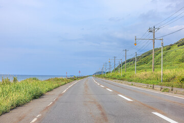 Fototapeta premium オロロンラインの曇り空に映える、夏のドライブ