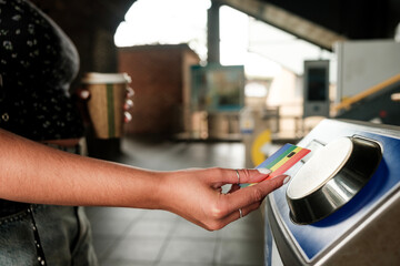 Woman using credit card to enter subway station