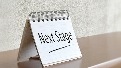テーブルに立てたメモ帳_NextStage文字入り