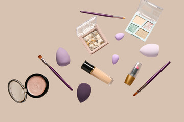 Flying decorative cosmetics on beige background