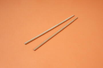 Wooden Chopsticks on a Light Orange Background
