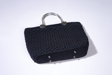 Stylish Black Woven Handbag with a Silver Handle on White Background