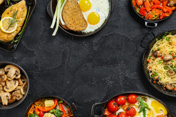 Frame made of different dishes on dark background