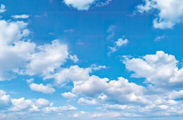 A vast expanse of a vibrant blue sky dotted with fluffy white clouds