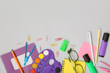 Eyeglasses and different stationery on grey background