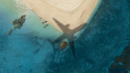 Aerial view of shadow passenger plane silhouette and sandy beach blue sea with waves at sea beach summer vacation sea travel concept	