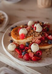 close-up stack of fluffy pancakes with red berries and coulis – tropical beach restaurant breakfast