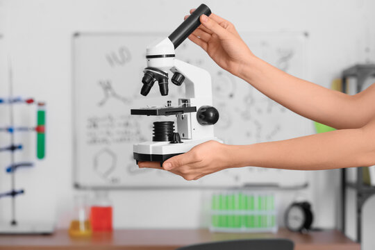 Teenage girl with modern microscope in room, closeup - Powered by Adobe