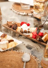 luxury gourmet dessert assortment plate close up with spoon at beach club restaurant table
