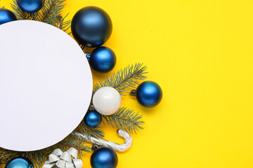 Blank card, Christmas balls, candy cane and fir branches on yellow background
