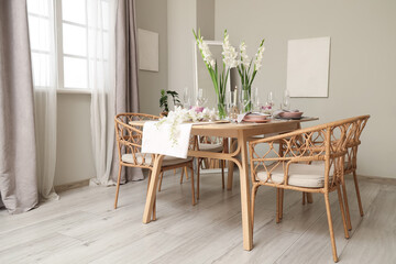 Interior of light room with served dining table and white Gladiolus flowers