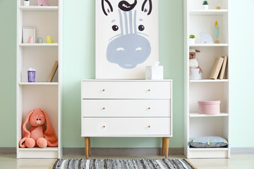 Interior of children's room with picture, commode and shelf units
