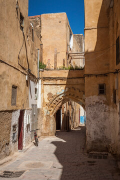 Bicycle leans near a Stone Gate in a Half-shaded Alleyway in the Fes Morocco Medina