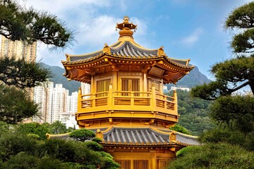 Fototapeta premium Pagoda in Nan Lian Garden, Hong Kong. Trees of the garden, Hong Kong skyline in the background. Cloudy sky overhead. 