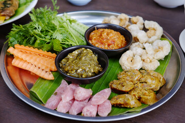 Northern Thai spicy green chilli dip with sausage and crackling with vegetable set on banana leaf is traditional Thai food
