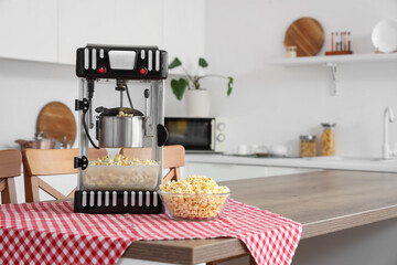 Modern popcorn machine on table in kitchen