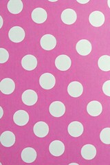 Seamless pattern of evenly spaced white polka dots on a bright pink textured background creating a cheerful and playful visual effect