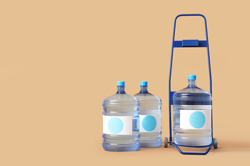 Trolley with bottles of clean water on beige background