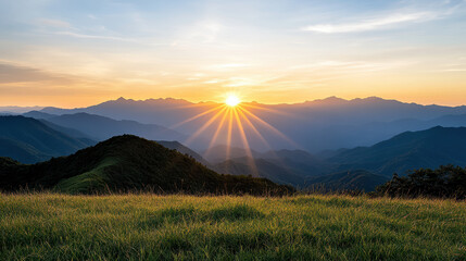 Obraz premium Breathtaking sunset over mountain range with vibrant rays illuminating landscape