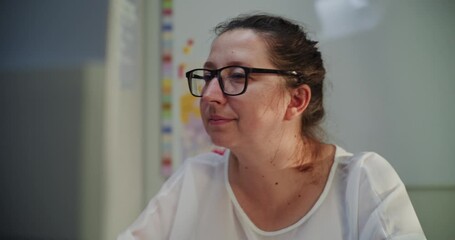 Primary School Teacher Working on Computer, Checking Homework and Online Tasks During E-Learning, Making Educational Plan for School Children. Woman Working at PC in Classroom in the Evening. Close Up - Powered by Adobe