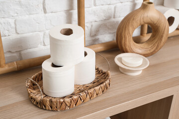 Rolls of toilet paper on shelving unit in stylish restroom, closeup