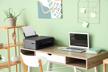 Workplace with modern printer and laptop in stylish home office