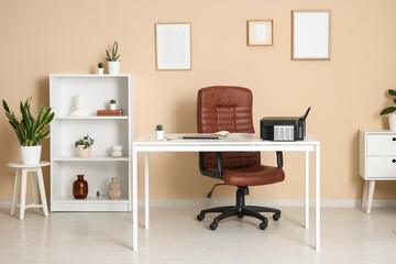 Workplace with modern printer, laptop and comfortable chair in stylish home office