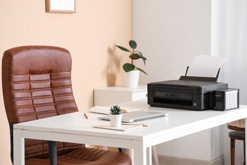 Workplace with modern printer, laptop and comfortable chair in stylish home office