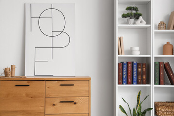 Shelving unit and wooden cabinet with decor, books and houseplant near white wall
