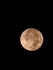 Full moon, bathed in a warm, earthy glow.