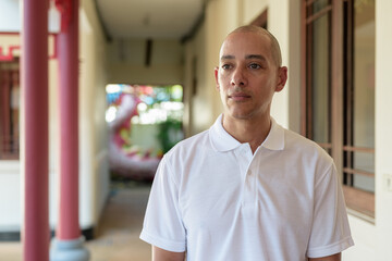 Obraz premium Stylish man in white polo shirt posing in tranquil Zen garden portrait