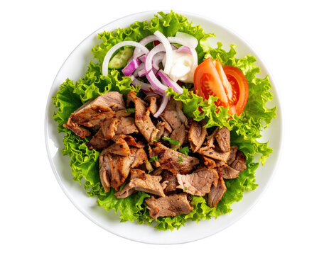 A plate of grilled doner kebab meat with fresh lettuce tomato onion and cucumber salad top view.