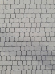 Texture of street tiles. Pattern of gray sidewalk tiles close up