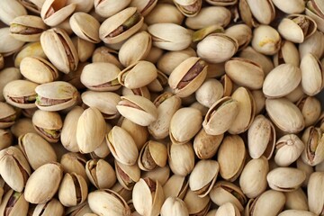 Tasty unpeeled pistachios as background, top view flat lay background